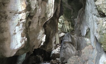 Inside view of Gua Batu Cermin with light beams reflecting off the cave walls