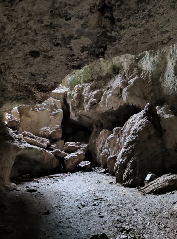 Inside view of Gua Batu Cermin with light beams reflecting off the cave walls