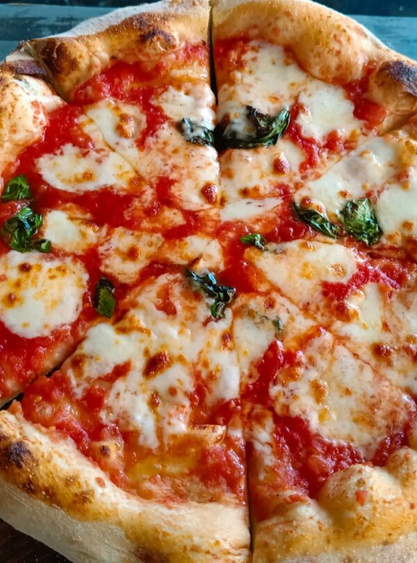 Wood-fired pizza topped with fresh ingredients at Fellas Pizzeria in Labuan Bajo, Flores, Indonesia