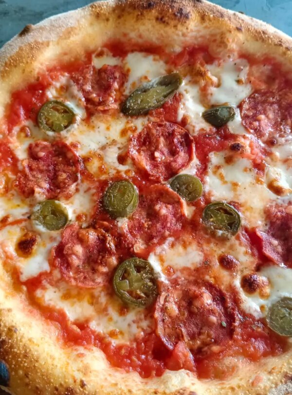 Wood-fired pizza topped with fresh ingredients at Fellas Pizzeria in Labuan Bajo, Flores, Indonesia