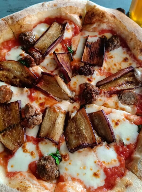 Wood-fired pizza topped with fresh ingredients at Fellas Pizzeria in Labuan Bajo, Flores, Indonesia