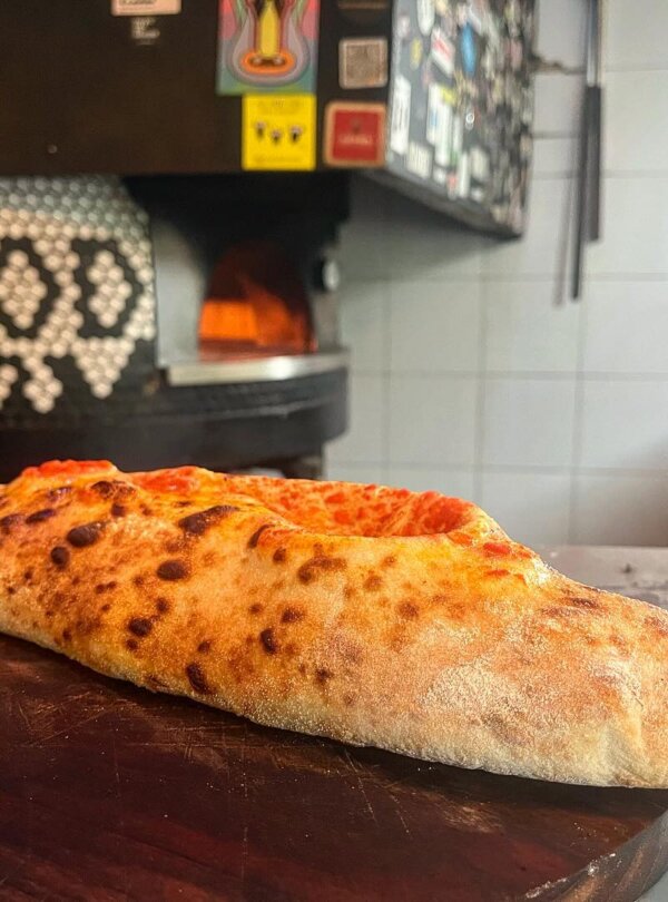 Wood-fired pizza topped with fresh ingredients at Fellas Pizzeria in Labuan Bajo, Flores, Indonesia