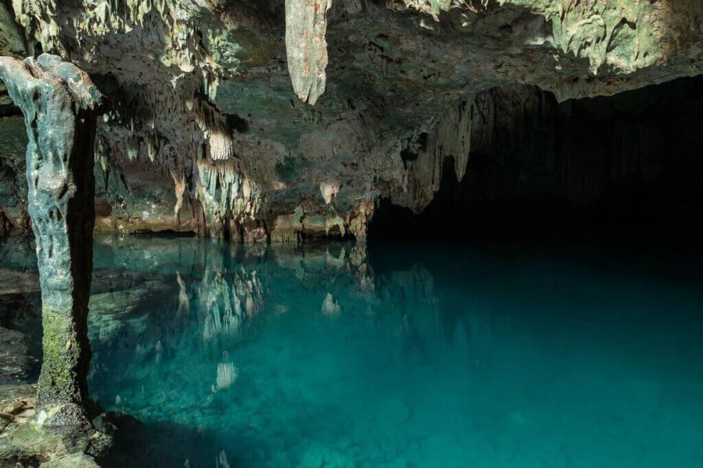 Sunlight streaming into the turquoise waters of Rangko Cave in Labuan Bajo