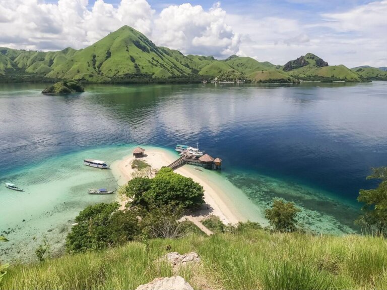 Aerial view of Kelor Island with its lush green hill and white sandy beach in Labuan Bajo