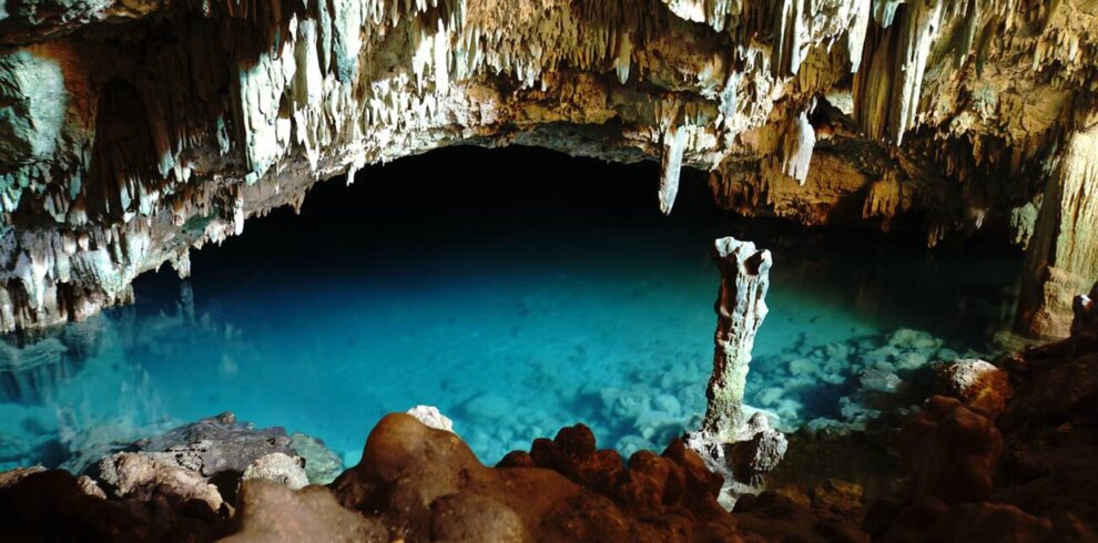 Sunlight streaming into the turquoise waters of Rangko Cave in Labuan Bajo