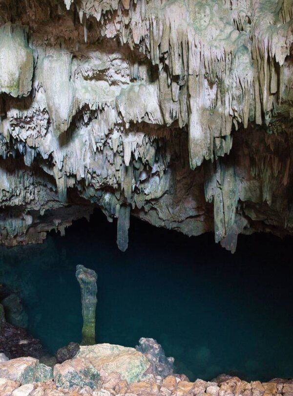 Sunlight streaming into the turquoise waters of Rangko Cave in Labuan Bajo