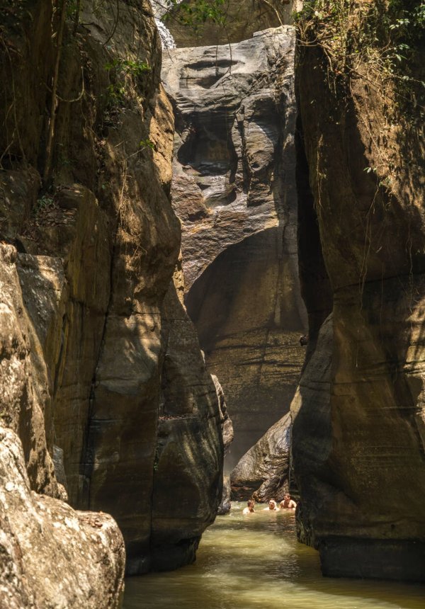 Cunca Wulang – Hidden Canyon and Waterfall in Flores Emerald green river flowing between steep canyon walls at Cunca Wulang Waterfall in Flores
