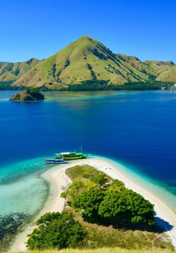 Kelor Island – Hilltop Views and White Sand Beach in Labuan Bajo Aerial view of Kelor Island with its lush green hill and white sandy beach in Labuan Bajo