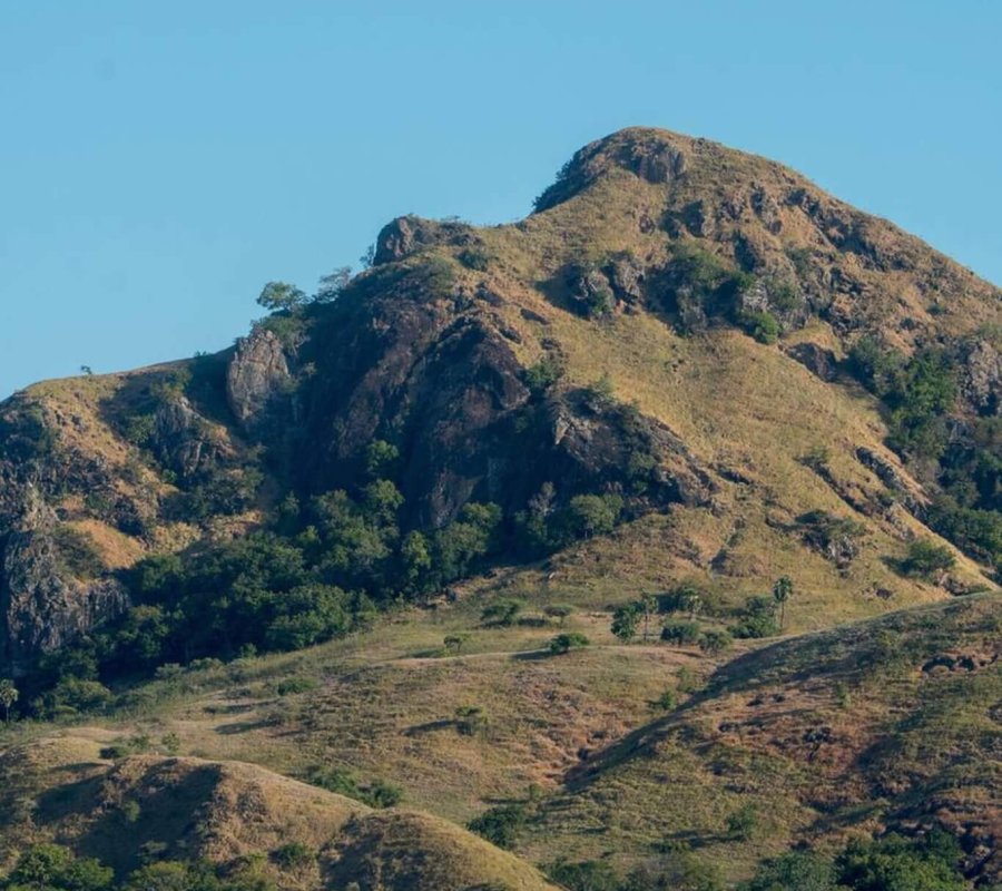 Kelor Island – Hilltop Views and White Sand Beach in Labuan Bajo Aerial view of Kelor Island with its lush green hill and white sandy beach in Labuan Bajo