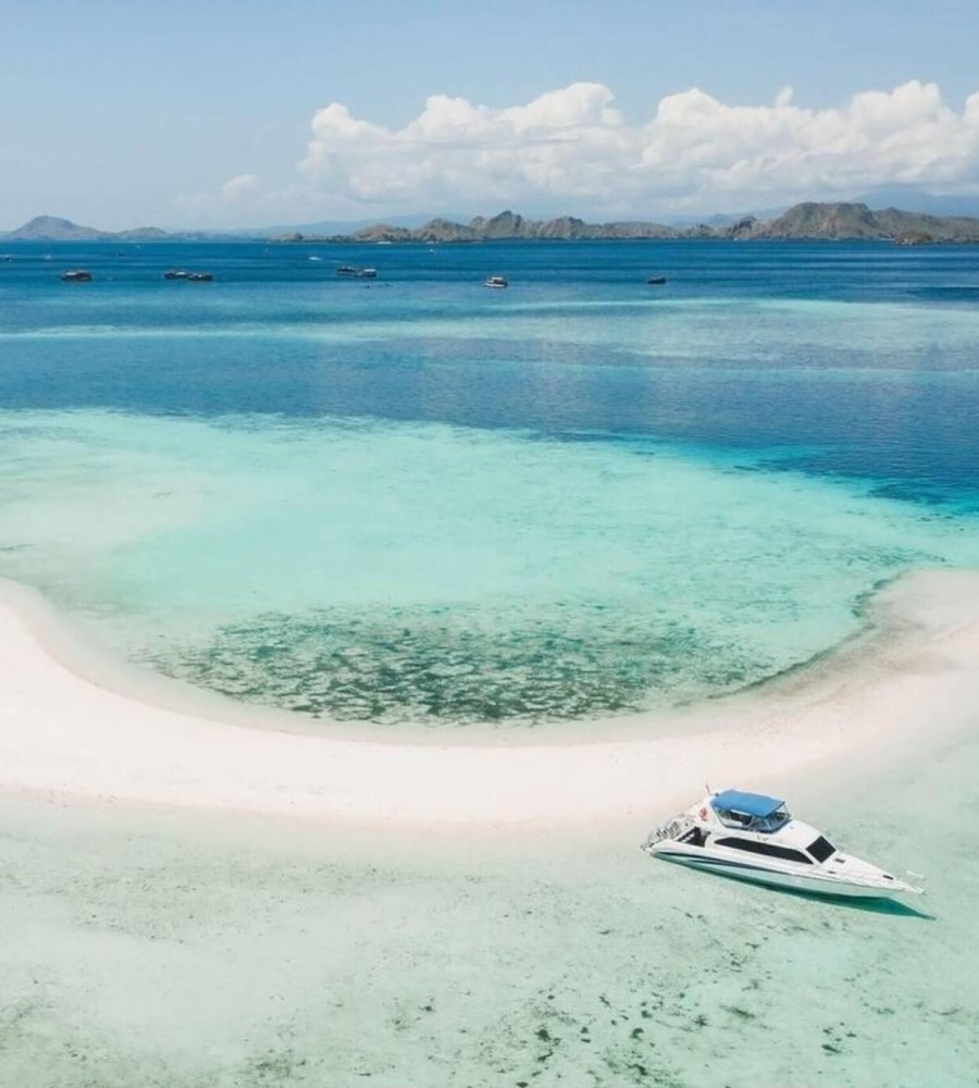 Taka Makassar – Crescent Sandbar in the Flores Sea Aerial view of Taka Makassar’s crescent-shaped sandbar surrounded by turquoise waters
