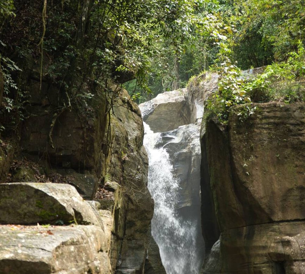 Cunca Wulang – Hidden Canyon and Waterfall in Flores Emerald green river flowing between steep canyon walls at Cunca Wulang Waterfall in Flores