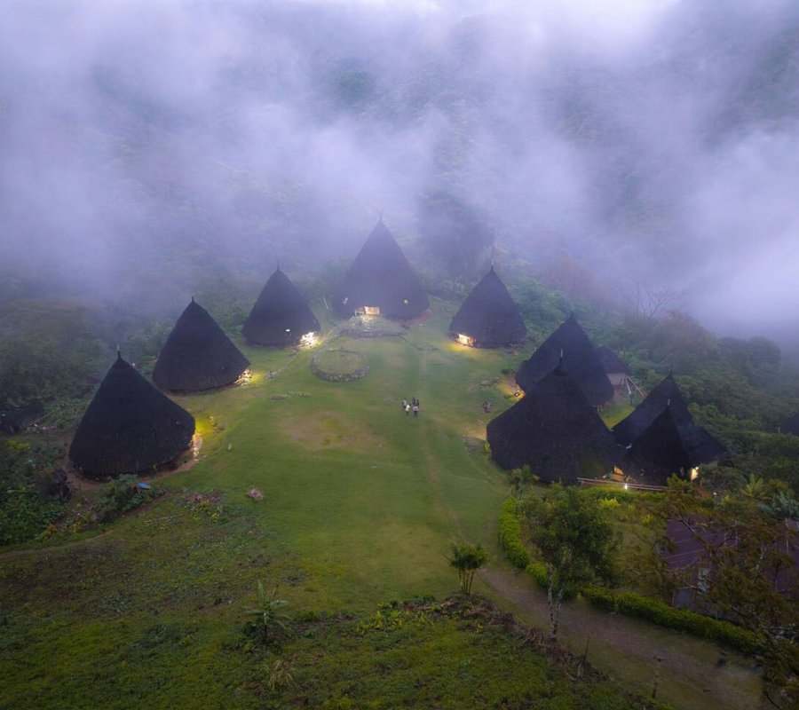 Wae Rebo Village – The Hidden Traditional Village in the Clouds Traditional conical houses of Wae Rebo Village surrounded by lush green mountains in Flores, Indonesia